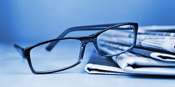 eyeglasses and newspaper blue background