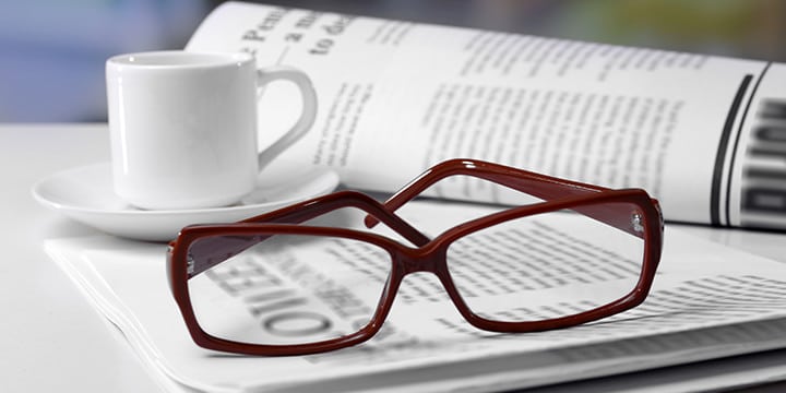 Eyeglasses with newspaper and coffee cup